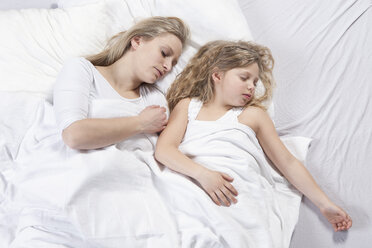 Germany, Bavaria, Munich, Mother and daughter sleeping on bed - RBF000687