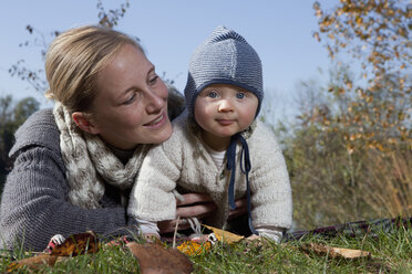 Deutschland, Bayern, München, Mutter mit kleinem Jungen im Gras liegend, Nahaufnahme - RBF000692