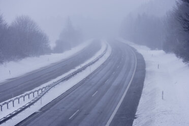 Deutschland, Oberbayern, Bundesautobahn 95, Blick auf Nebel und Schnee auf leerer Autobahn - TCF001441