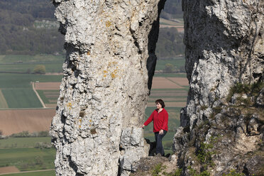 Deutschland, Bayern, Franken, Fränkische Schweiz, Walberla, Blick auf reife Frau beim Wandern in der Nähe von Felsformationen am Berg - SIEF001407