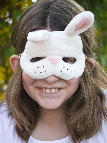 Deutschland, Bayern, Nahaufnahme eines Mädchens mit Osterhasenmaske, lächelnd, Porträt, lizenzfreies Stockfoto