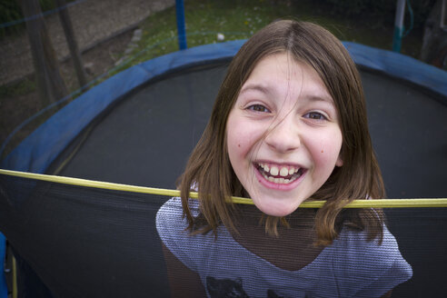 Deutschland, Bayern, Mädchen springt auf Trampolin, lächelnd, Porträt - LFF000259