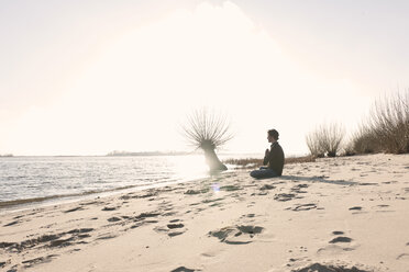 Germany, Hamburg, Man doing yoga exercise near Elbe riverside - DBF000128