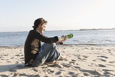 Germany, Hamburg, Man pouring wine in glass near Elbe riverside - DBF000133