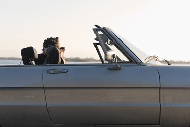 Germany, Hamburg, Man sitting in classic cabriolet car near Elbe riverside - DBF000137