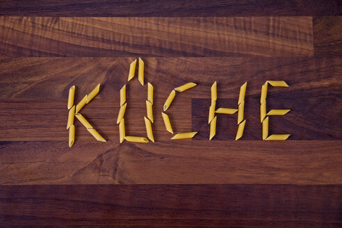 Close up of word kitchen written with penne on wooden background - TSF000256