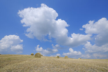 Italien, Toskana, Provinz Siena, Val d'Orcia, Pienza, Blick auf Heuballen im Feld mit dramatischen Wolken - RUEF000677