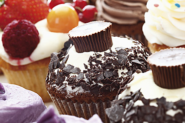 Nahaufnahme eines Buttercreme-Cupcakes mit Schokoladenstreuseln und Schokoladenbonbons - CSF014999