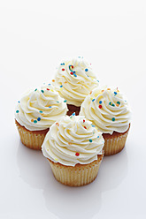 Nahaufnahme eines Vanille-Cupcakes mit Buttercreme vor weißem Hintergrund - CSF014981