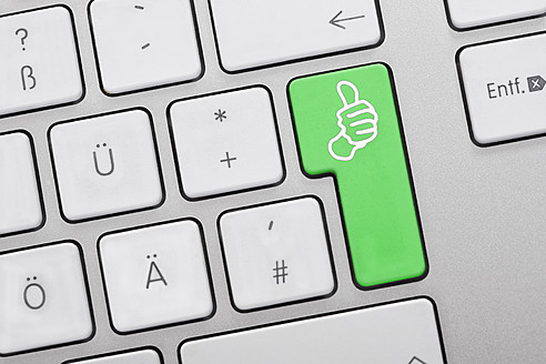 Close up of computer keys with thumbs up symbol on green key - TSF000267