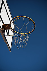 Germany, North Rhine-Westphalia, Düsseldorf, Empty basketball hoop against blue sky - KJF000082