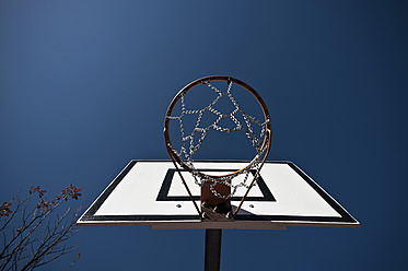 Germany, North Rhine-Westphalia, Düsseldorf, Empty basketball hoop against blue sky - KJF000100