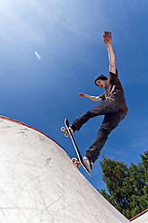 Belgium, Flemalle, Young man skate boarding in skatepark - KJF000107