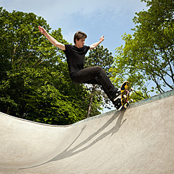 Deutschland, NRW, Düsseldorf, Mann fährt Skateboard in öffentlichem Skatepark - KJF000113