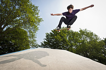 Deutschland, NRW, Düsseldorf, Mann fährt Skateboard in öffentlichem Skatepark - KJF000114