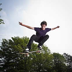 Germany, NRW, Duesseldorf, Man skateboarding at public skatepark - KJF000115