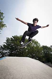 Deutschland, NRW, Düsseldorf, Mann fährt Skateboard in öffentlichem Skatepark - KJF000116