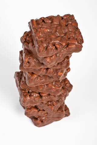 Stapel von mit Schokolade überzogenem Puffreis auf weißem Hintergrund, lizenzfreies Stockfoto
