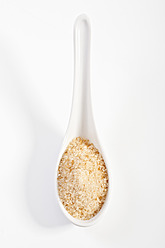Brauner Zucker in Porzellanlöffel auf weißem Hintergrund - TSF000293