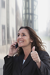 Deutschland, Köln, Rheinauhafen, Nahaufnahme einer Geschäftsfrau beim Telefonieren am Rhein - GWF001498