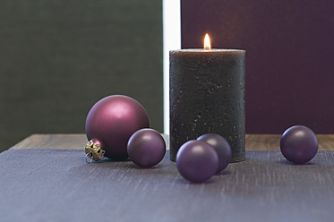 Nahaufnahme von Weihnachtskugel und Kerze auf dem Tisch - ASF004358