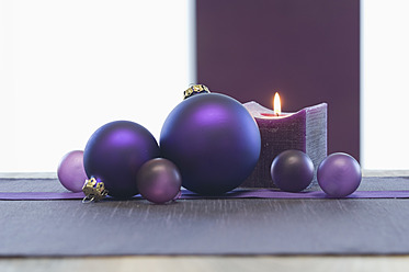 Nahaufnahme von Weihnachtskugel und Kerze auf dem Tisch - ASF004359