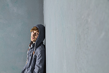 Junger Mann stehend und an eine schmutzige Wand gelehnt, Porträt - MBEF000131