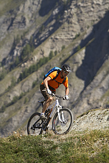 Italien, Livigno, Blick auf einen Mann, der in der Nähe eines Berges Mountainbike fährt - FFF001164