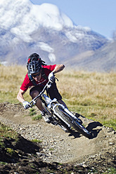 Italy, Livigno, View of man riding mountain bike downhill - FFF001175