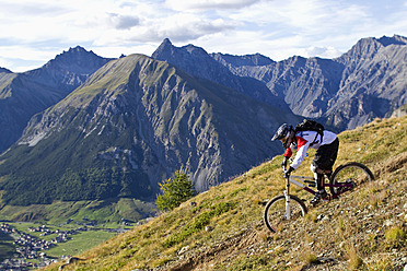 Italien, Livigno, Blick auf einen Mann, der mit dem Mountainbike bergab fährt - FFF001182