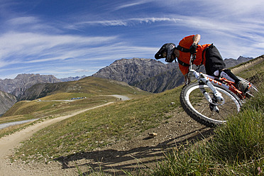 Italien, Livigno, Blick auf einen Mann, der mit seinem Mountainbike bergab fährt - FFF001188