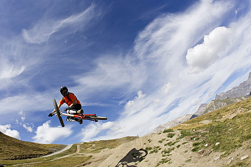 Italien, Livigno, Blick auf einen Mann, der mit einem Mountainbike springt - FFF001190