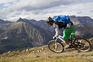 Italien, Livigno, Blick auf einen Mann, der mit dem Mountainbike bergab fährt - FFF001192