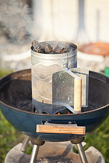 Germany, Close up of barbecue grill with smoke coming out of it - MAEF003414