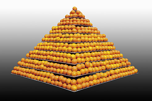 Stapel von Orangen in Pyramidenform vor grauem Hintergrund - CSF015212