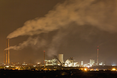 Germany, Nordrhein-Westfalen, Duisburg, View of smoke stacks of industrial plant at night - FOF003426