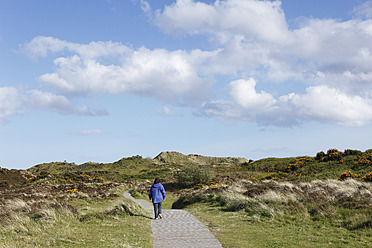 Vereinigtes Königreich, Nordirland, County Down, Newcastle, Mourne Mountains, Murlough National Nature Reserve, Person, die in der Nähe der Dünen spazieren geht - SIEF001605