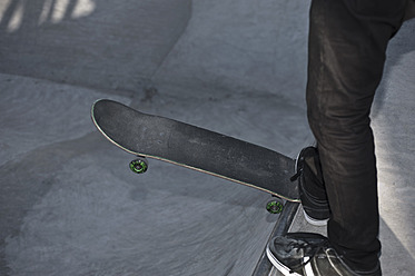 Deutschland, Nordrhein-Westfalen, Münster, Skateboarder fällt mit dem Bein in Skatebowl in öffentlichem Skatepark - KJF000149