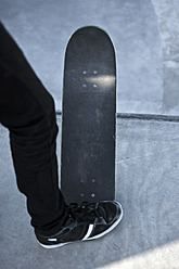 Deutschland, Nordrhein-Westfalen, Münster, Skateboarder steht an Skatebowl in öffentlichem Skatepark - KJF000150
