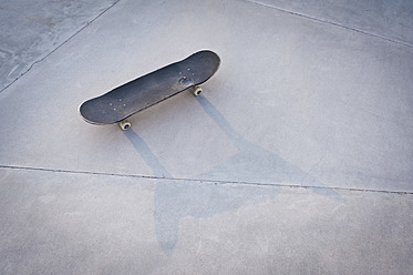 Belgium, Mechelen, Skateboard lying on ground in public skatepark - KJF000125