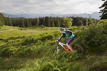 Österreich, Tirol, Spitzstein, Junge Frau beim Mountainbiken - FFF001204