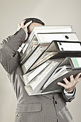 Close up of mature businessman at office holding stack of file - MAEF003434