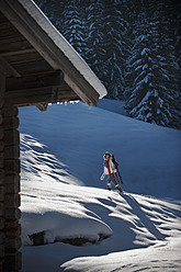 Österreich, Salzburger Land, Flachau, Junge Frau geht mit Schlitten im Schnee - HHF003691