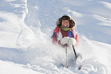 Österreich, Salzburger Land, Flachau, Junge Frau fährt auf Schlitten im Schnee - HHF003692