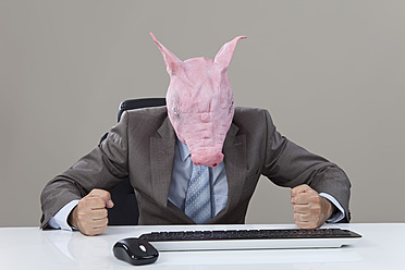 Nahaufnahme von Geschäftsmann mit Schweinen Kopf schlagen Tisch im Büro gegen grauen Hintergrund - MAEF003484