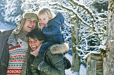 Österreich, Salzburger Land, Flachau, Familie im Schnee stehend, lächelnd - HHF003721
