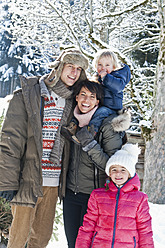 Österreich, Salzburger Land, Flachau, Blick auf Familie im Schnee stehend, lächelnd, Porträt - HHF003722