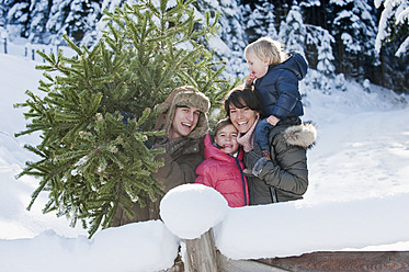 Austria, Salzburg Country, Flachau, View of family with christmas tree in snow - HHF003728