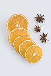 Close up of orange slices and star anise against white background - CRF002076