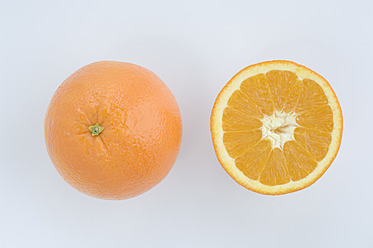 Nahaufnahme einer Orangenscheibe und einer ganzen Orange vor weißem Hintergrund - CRF002077